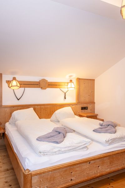 Doppelzimmer mit Holzmöbeln und Wandleuchten
