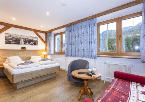 Gästezimmer mit Doppelbett und Sitzecke am Fenster