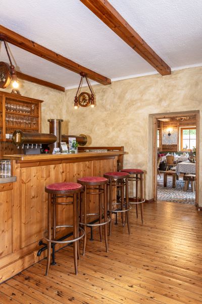 Holztheke mit Barhockern im Stüberl